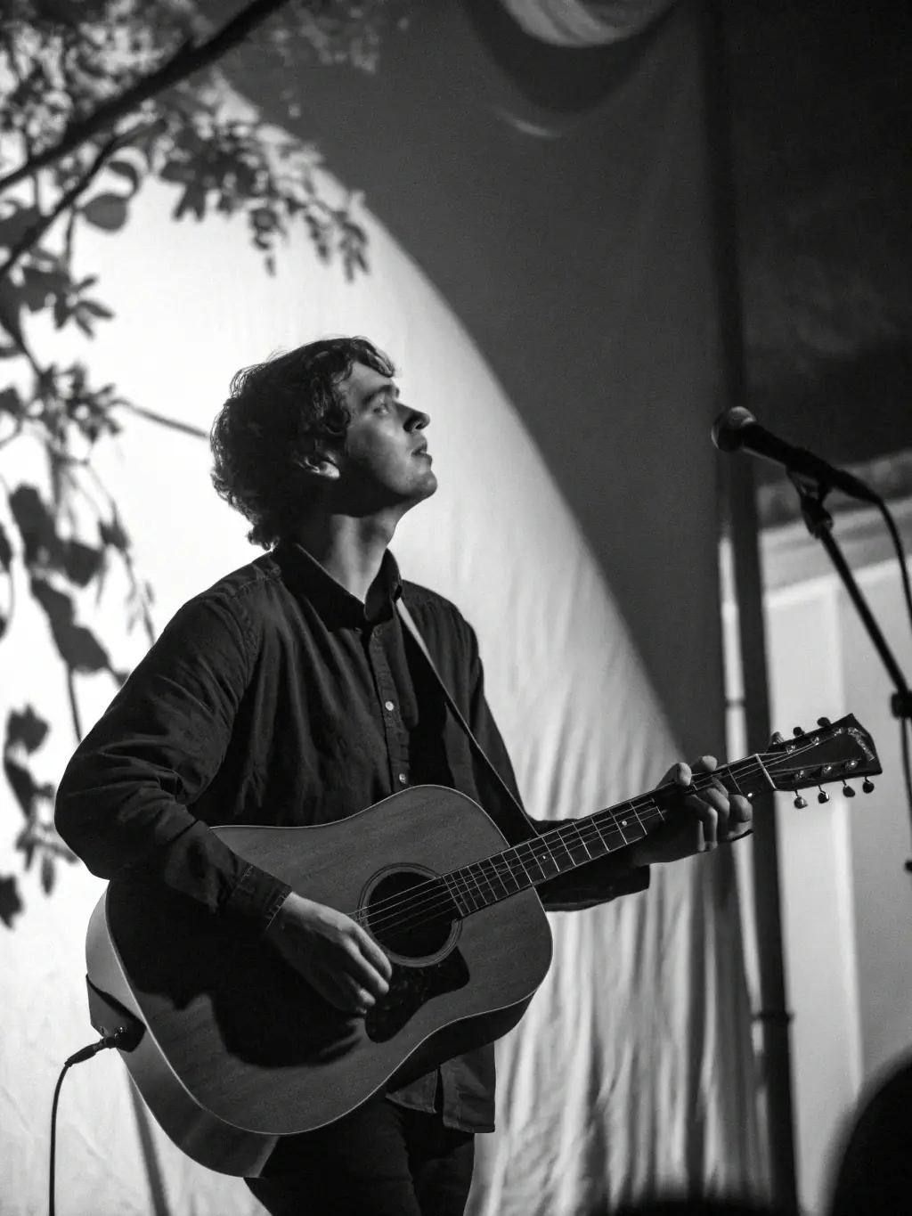 A captivating image of a solo musician passionately playing a guitar on a dimly lit stage during the TOUT SEUL DEVANT TOUT LE MONDE festival, showcasing the raw emotion and talent of the performer.