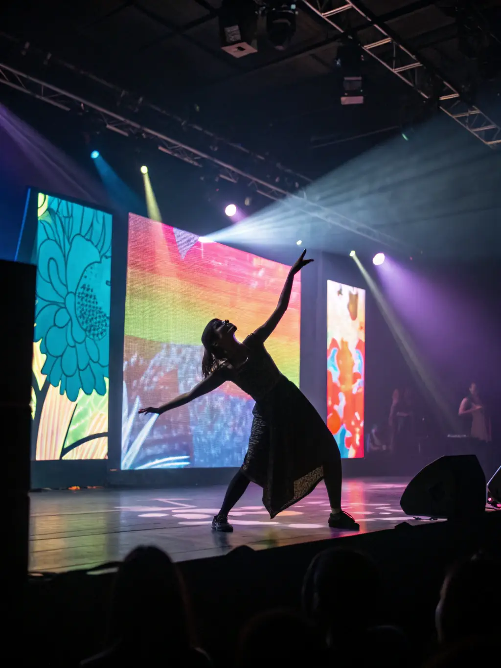 A dynamic photograph of a solo dancer gracefully moving across the stage, bathed in vibrant colors, during a performance at the TOUT SEUL DEVANT TOUT LE MONDE festival.