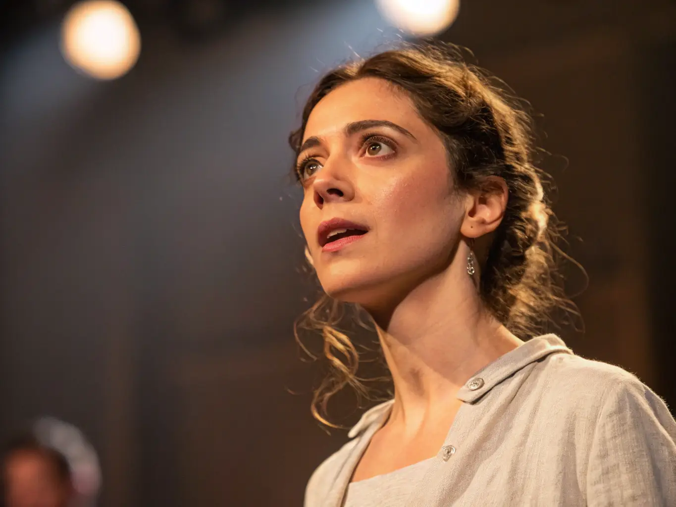 A striking image of a solo theatre performer delivering a monologue on stage, with dramatic lighting and expressive gestures, showcasing the power of storytelling at the TOUT SEUL DEVANT TOUT LE MONDE festival.